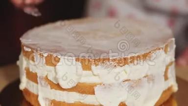在<strong>一个</strong>旋转的盘子上特写奶油蛋糕，库克正在用<strong>勺子</strong>触摸它